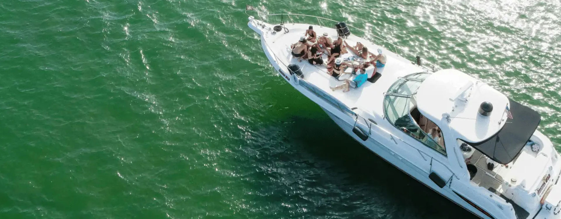 a boat with people on it in the water. featuring South Florida boating and private yacht rentals in Boca Raton