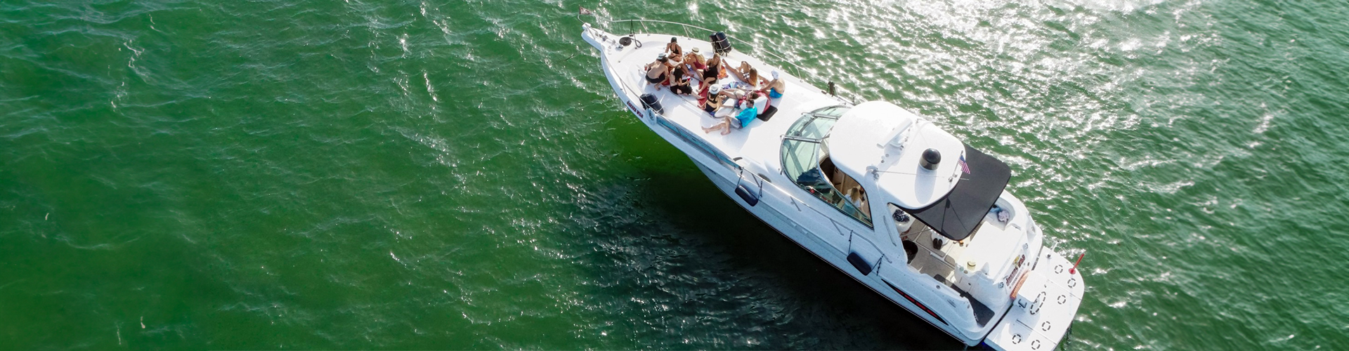 a boat is in the water with a group of people. featuring South Florida boating and private yacht rentals in Fort Lauderdale by Aquaholics Florida