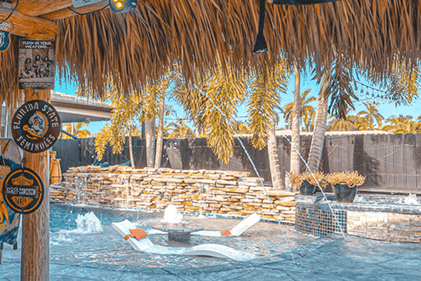 a pool with a waterfall and a tree. featuring South Florida boating and luxury boat events