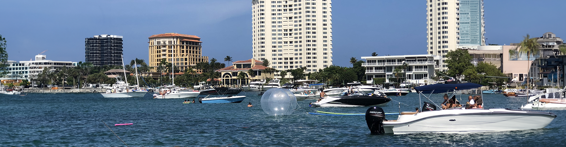 a harbor filled with lots of boats and buildings. featuring luxury boat events and boat parties by Aquaholics Florida