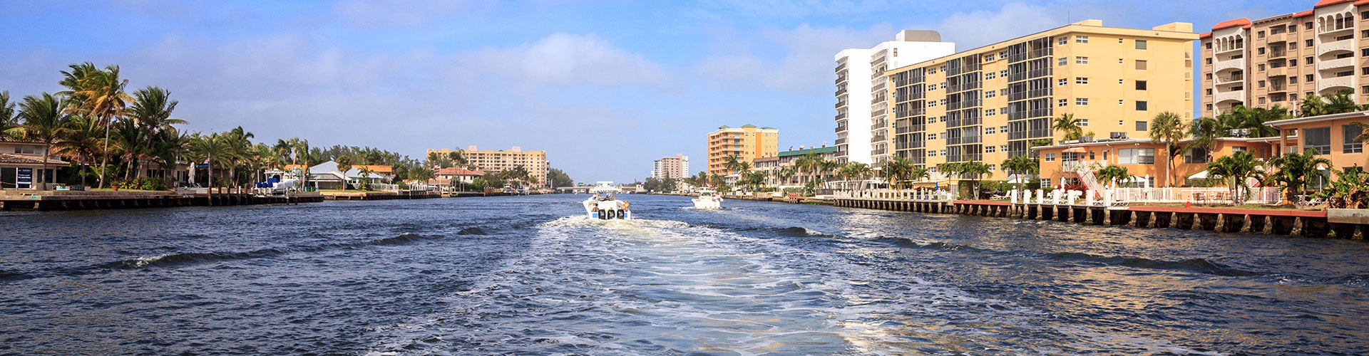 a river with a boat going by. featuring Intracoastal Waterway cruises and yacht charters in Pompano Beach