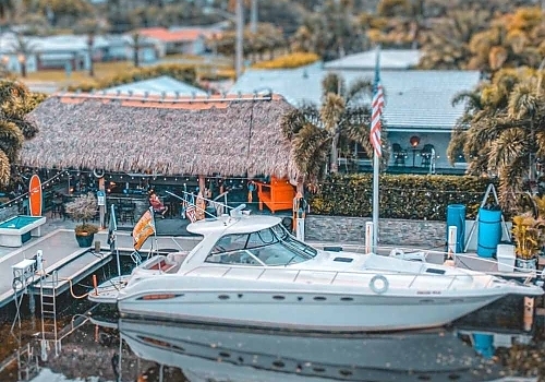 a boat is docked at a pier with a crowd of people. featuring Boca Raton and yacht charters